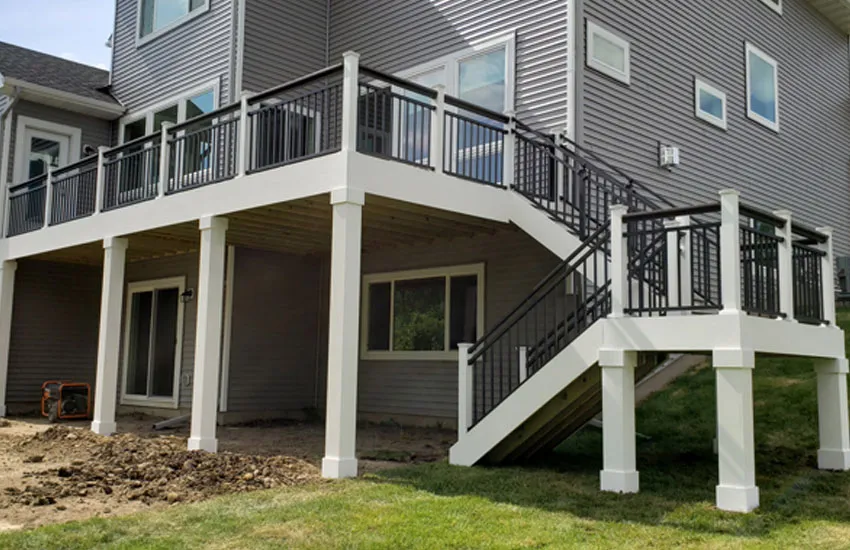 White PVC wrapped columns supporting elevated deck with black aluminum railings
