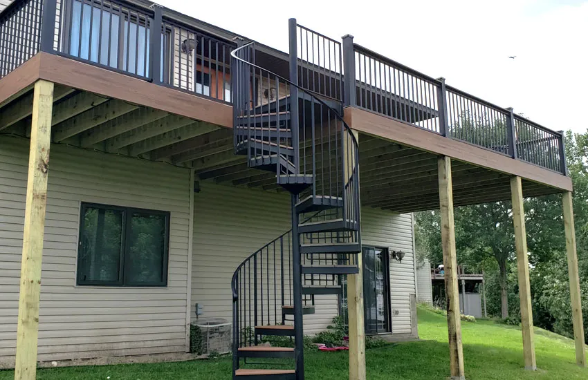 Metal spiral staircase connecting second-story deck to ground level on Minnesota home