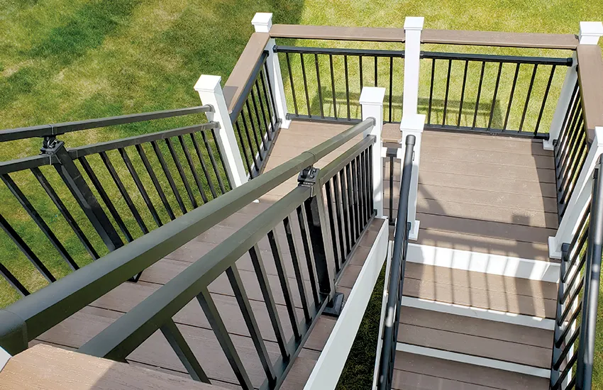 U-shaped deck stairs with brown composite treads and white posts with black balusters