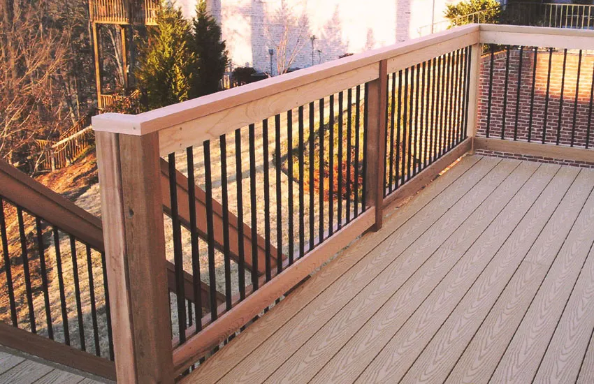 Natural cedar wood railing posts with black metal balusters on composite deck