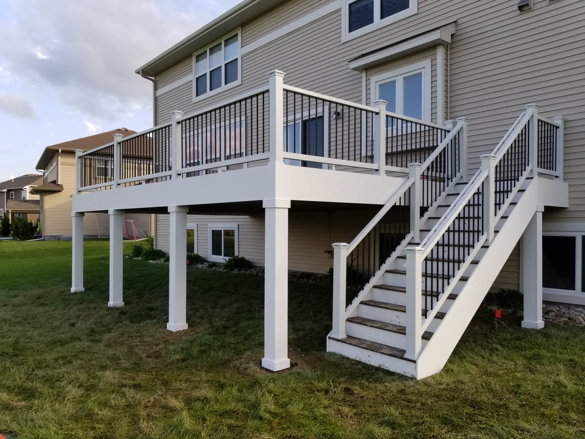 Elevated deck featuring classic white posts and composite decking materials